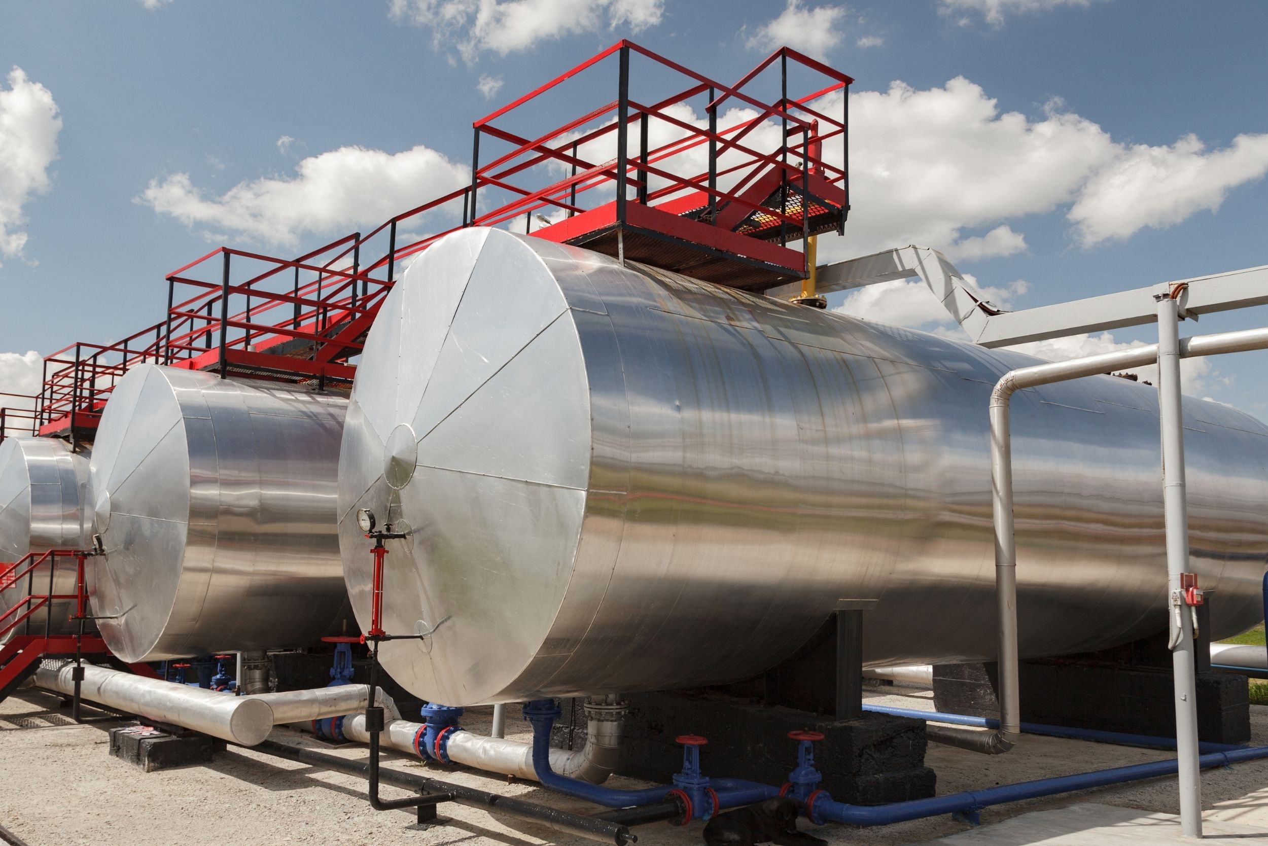 Large stainless steel liquid containers horizontally next to one another